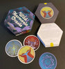 A hexagonal box labeled Wild Harmonic Oracle Cards by Schiffer Publishing, Ltd. sits open, showing colorful chakra cards with abstract designs and a booklet inside. Three alchemy-themed cards are displayed on a dark surface.