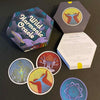 A hexagonal box labeled Wild Harmonic Oracle Cards by Schiffer Publishing, Ltd. sits open, showing colorful chakra cards with abstract designs and a booklet inside. Three alchemy-themed cards are displayed on a dark surface.