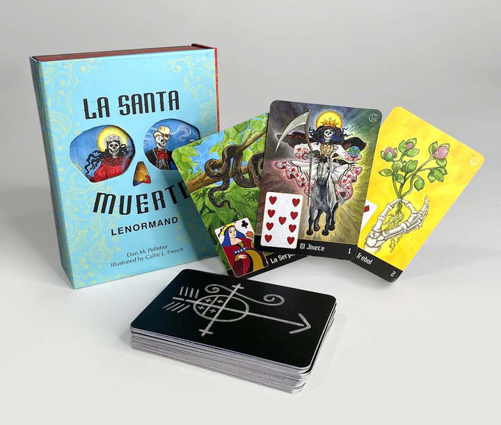 A box of La Santa Muerte Lenormand by Schiffer Publishing, Ltd. stands upright beside fanned divination cards, showcasing black card backs each decorated with a bold white mystical symbol.
