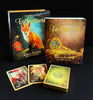 The Lenormand of Enchantment deck set by Schiffer Publishing, Ltd. showcases Yasmeen Westwood’s enchanting illustrations and a fox on the box, with three cards, a guidebook, the deck, and two boxes shown on a black surface.