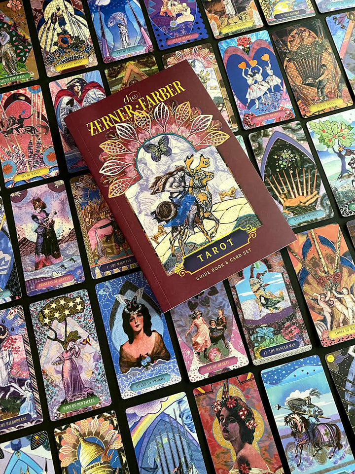 A vibrant Tarot deck with intricate art is spread out, topped by The Zerner/Farber Tarot set from Schiffer Publishing, Ltd., its whimsical guidebook beckoning you to explore your psychic potential.