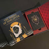 The Doors of Somlipith by Schiffer Publishing, Ltd. is an esoteric card reading set with a book and a deck featuring a gold-embossed lion face, all displayed in a decorative red and black box.