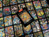 A vibrant display of Bonefire Tarot cards by Schiffer Publishing, Ltd. features colorful, hand-painted illustrations. The deck’s box displays a golden pentacle, resting atop scattered cards filled with expressive, mystical imagery.
