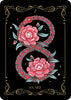 A stylized card from the Nocturnal Garden Lenormand by Schiffer Publishing, Ltd. shows a red and teal snake in a figure-eight around pink flowers on black with gold borders. The card is marked “7” and “SNAKE.”.