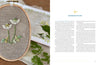 An embroidery hoop displays white and yellow daisies, inspired by Noriko Livingstone’s designs. To the right is "Wild Embroidery" by Schiffer Publishing, Ltd., with decorative text and green fern leaves scattered below.