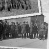 Two black-and-white photos from "Panzergrenadier Divisions of the Waffen-SS" (Schiffer Publishing, Ltd.) show uniformed officers outdoors during an inspection—some reviewing documents, others in formation. A typewritten caption is visible below.