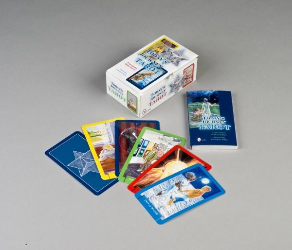 Today's Journey Tarot by Schiffer Publishing, Ltd. is shown on a gray surface with the vibrant deck, cards face up, and a blue guidebook—ideal for exploring spiritual insights through vivid illustrations.