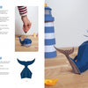 The "Paper Joy for Every Room" guide by Schiffer Publishing, Ltd. features step-by-step photo instructions to assemble a blue paper whale craft, shown finished on a wooden table beside a lighthouse and decorative houses.