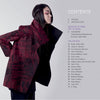 A woman with long dark hair models a textured, oversized red and black wearable fiber art jacket, standing in profile. Next to her is the table of contents for Artistry in Fiber, Vol. 3 by Schiffer Publishing, Ltd.