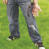 A person in ripped jeans and sneakers stands on grass, gently holding a baby squirrel—an image fitting for "Squirrel Rescue" by Schiffer Publishing, Ltd., a perfect children's book about wildlife rescue.