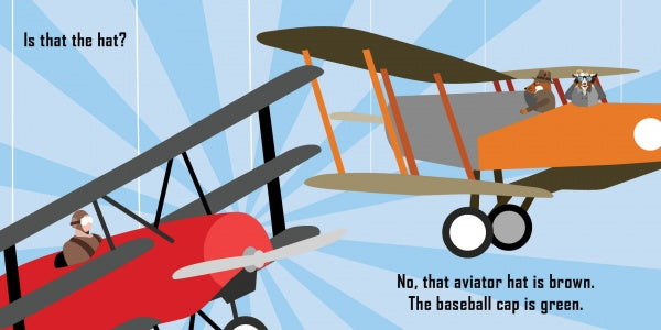 In Schiffer Publishing, Ltd.’s toddler board book "The Vanishing Baseball Cap," two cartoon planes soar as one pilot wears a brown aviator hat and the other a green baseball cap. Text asks, “Is that the hat?” and clarifies the aviator hat is brown, while the cap is green.
