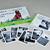 Simple Wisdom of the Household Dog by Schiffer Publishing, Ltd. is displayed, featuring a book and black-and-white dog oracle cards inspired by the household dog tarot, all spread out in front.