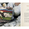 A colorful, knitted amulet pouch rests on smooth gray rocks. On the right, a page from The Art of Weaving a Life by Schiffer Publishing, Ltd. explores amulets and their meaning in one's inner life.