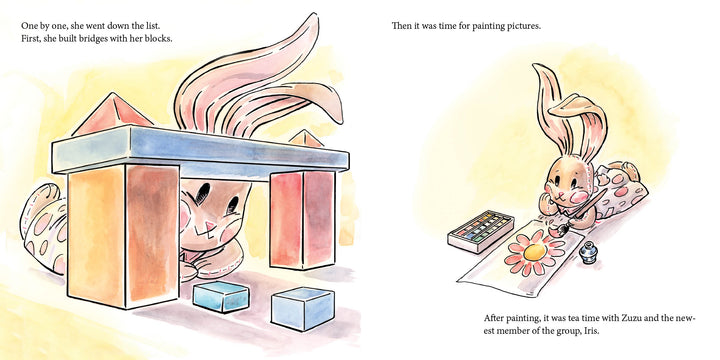 In Schiffer Publishing, Ltd.'s "Traveling Rose," a stuffed rabbit joyfully builds a block bridge on the left and paints a flower with watercolors on the right, surrounded by art supplies in a whimsical, storybook-like scene.